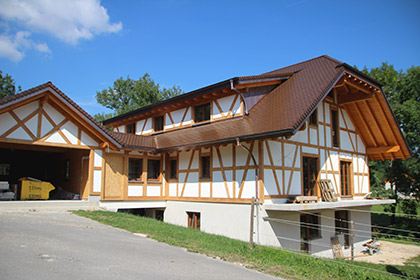 Holzhaus verputzt mit einer roten Wand